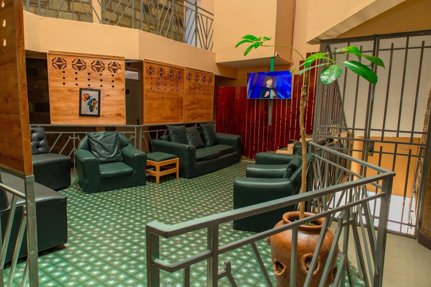 Lounge with green leather sofas and a red timber staircase